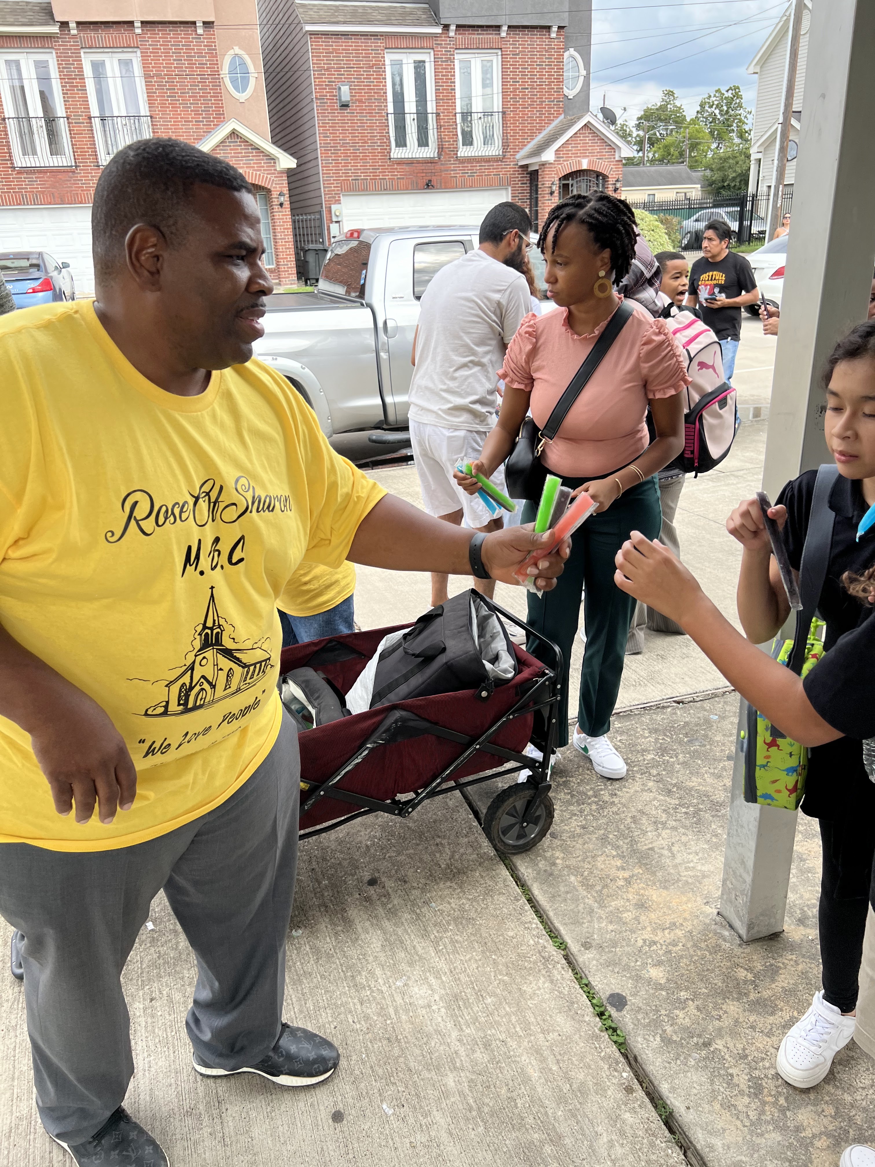 Volunteer handing out popsicles to children